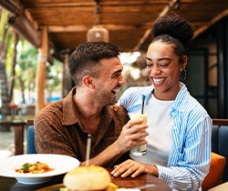 Couple smiling while enjoying meal at restaurant