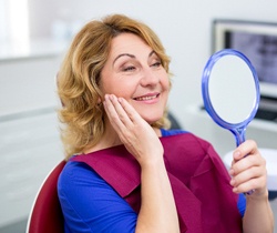 Woman smiling in hand mirror