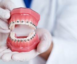 Dentist showing model of teeth with braces in Coppell