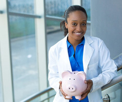 smiling dentist holding a piggy bank
