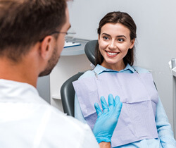 dentist talking to smiling patient at appointment