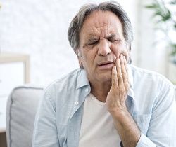 man in pain needing an emergency dentist in Coppell