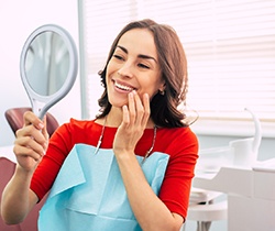 Woman admiring her veneers in Coppell 