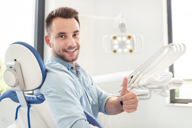 Man giving a thumb’s up at his dental checkup.