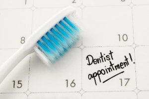 Toothbrush next to dentist appointment on calendar