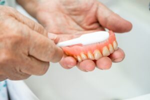 Person cleaning their dentures